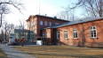 Instytut Teatralny im. Zbigniewa Raszewskiego i Główna Biblioteka Lekarska im. Stanisława Konopki w klimacie jesieni. Zdjęcie od frontu, czerwone cegły, wyblaknięta trawa.