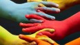 Grafika przedstawia splecone razem dłonie w kolorach tęczy.