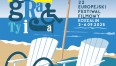 Grafika przedstawia dwa plażowe leżaki na tle morza oraz parasol. Całość utrzymana jest w palecie błękitu, granatu, bieli i żółci.