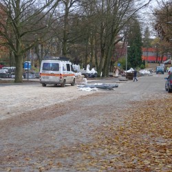 Przebudowana ulica Piastowska z nową drogą rowerową. Na drodze widać jesienne liście. Po lewej stronie jest auto pogotowia elektrycznego.