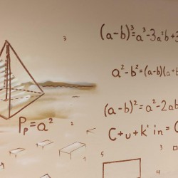 obrazek w kolorze przedstawiający fragment ściany w pracowni lekcyjnej z wyliczeniami matematycznymi