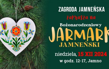 Grafika przedstawia kolorową ozdobę świąteczną w kształcie serca na tle gałęzi świerku