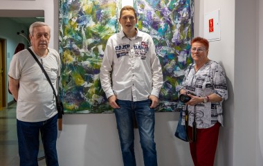 Artysta Marek Kuderko z rodzicami na tle swoich prac