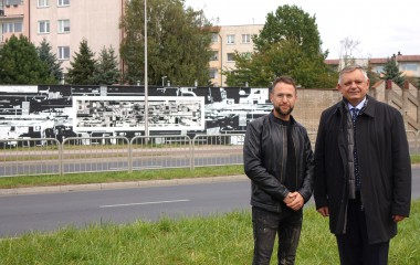 Na zdjęciu Prezydent Miasta Koszalina Piotr Jedliński i twórca muralu Maciej Mazurkiewicz na tle czarno białego, graficznego murali z ceramicznymi elementami