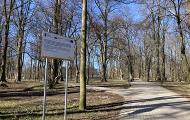 Park im. T. Kościuszki po realizacji projektu na obrazku tablica informacyjna, nowa aleja z rozwidleniem, na obrazku widać drzewa i krzewy