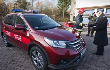 Czerwony samochód operacyjny straży pożarnej z wyposażeniem do analizy rozpoznania zagrożeń.